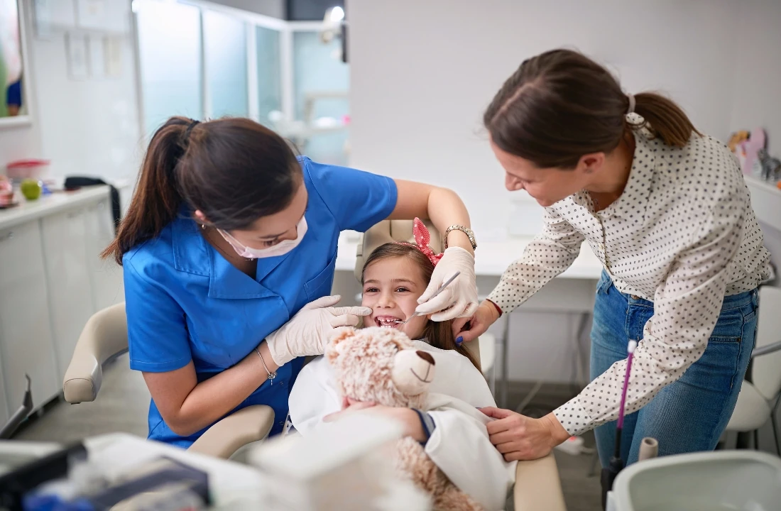 Dentist esch examining a young girl